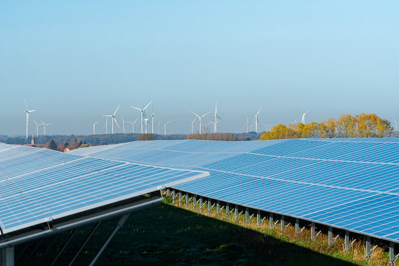 Panneaux photovoltaïques et éoliennes en arrière-plan : une solution pour produire de l'électricité verte.