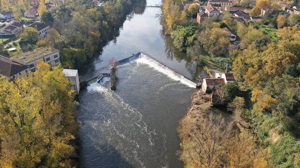 Vue aérienne d'un barrage et de son inscription dans le paysage semi-urbain.