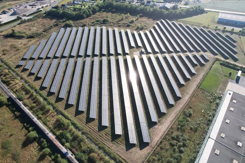 Vue aérienne d'une centrale au sol composée de plusieurs panneaux photovoltaïques.