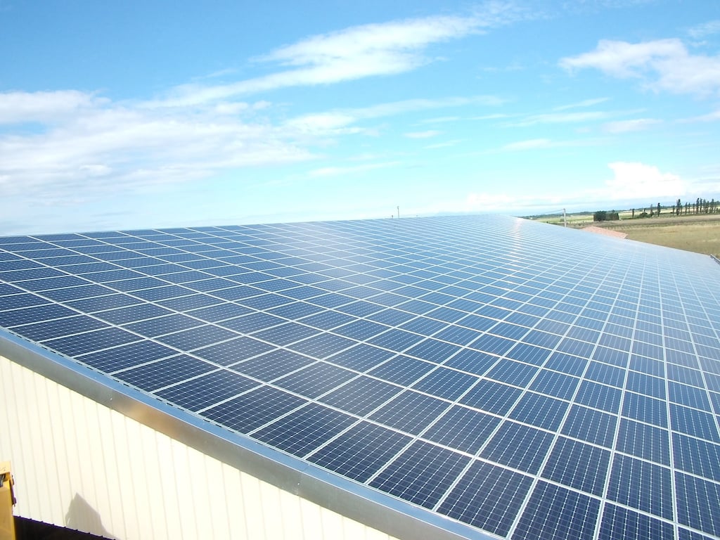 Panneaux photovoltaïques installés sur le toit d'un hangar à la campagne.